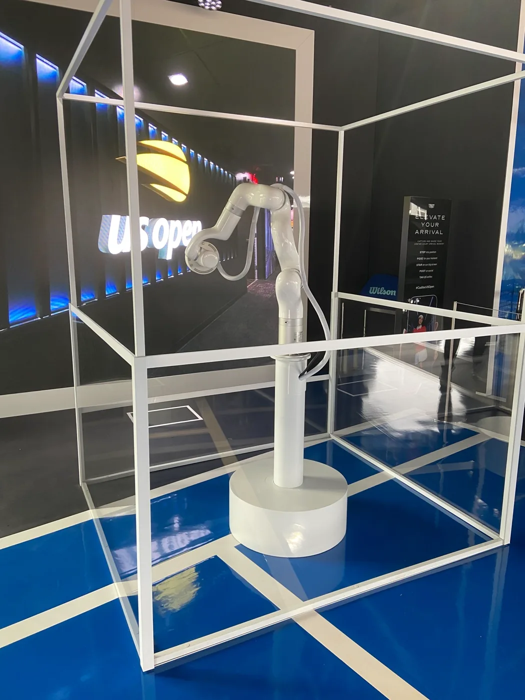 The arm in its vitrine on the show floor, US Open wall behind